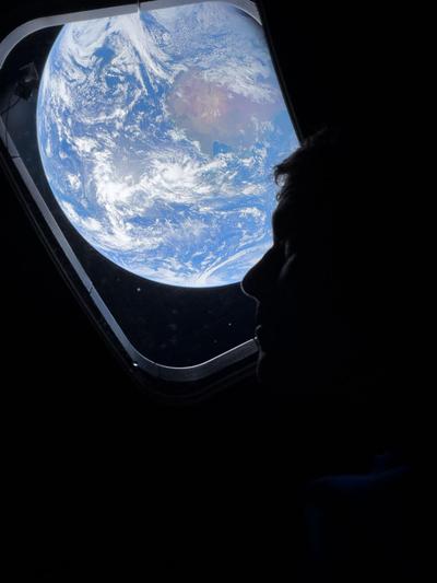 Astronaut silhouette with Earth through the window, portrait
